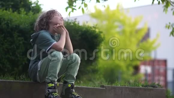 可怜体贴的小学生坐在路边站起来离开少年滚筒卷发男孩视频的预览图