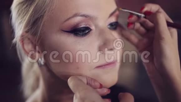 漂亮的金发美女化妆师做一个时尚的化妆视频的预览图
