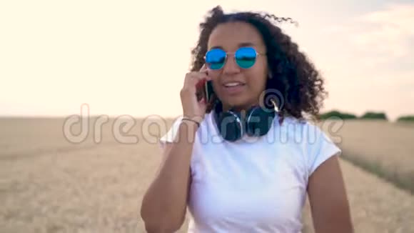 穿着白色T恤和蓝色太阳镜的非洲裔美国少女年轻女性在她的智能手机上交谈视频的预览图
