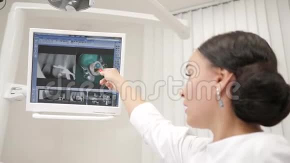 牙医给病人在椅子上的一位年轻的非裔美国男性病人看了一张X光照片视频的预览图