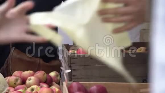 消费者在城市果蔬市场选择红苹果买家在农贸市场采摘多汁的红苹果视频的预览图