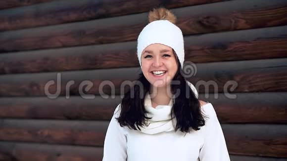 一个穿着白色夹克和白色帽子的快乐迷人女孩的肖像视频的预览图