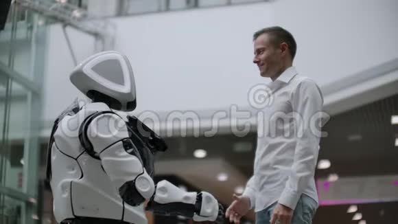 人与人工智能现代技术的互动紧紧抓住科学家的男性手摇动机器人视频的预览图