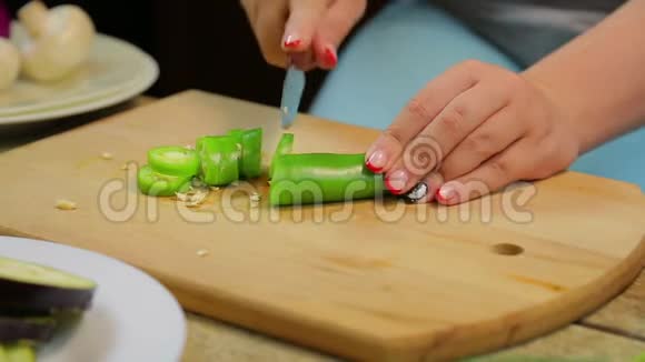 女人用一把刀在木板上切出青长辣椒时间跨度视频的预览图