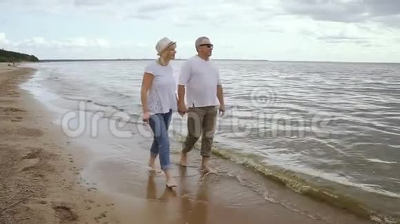 老两口周末去海边玩快乐的退休人士在海边散步视频的预览图
