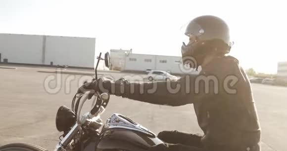男子骑摩托车在城市的道路上日落侧视视频的预览图