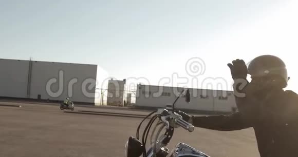 骑摩托车的人骑摩托车在道路上日落在城市侧视视频的预览图