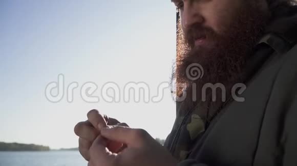 渔夫把一条虫子放在钩子上有胡子的成年男子把皮尔特放在钩子上的肖像用活鱼饵钓鱼视频的预览图