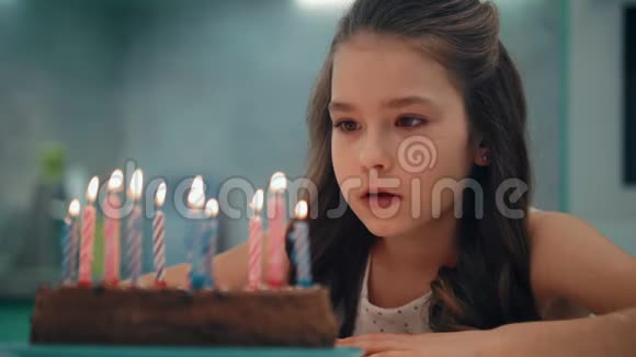 慢动作吹蜡烛的女孩肖像儿童生日快乐概念视频的预览图