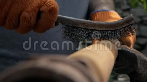 一个男人的手在工作手套特写用金属刷子把旧管子从生锈中清理出来视频的预览图
