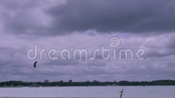 在暴风雨的天空中在海滩上放风筝的男孩视频的预览图