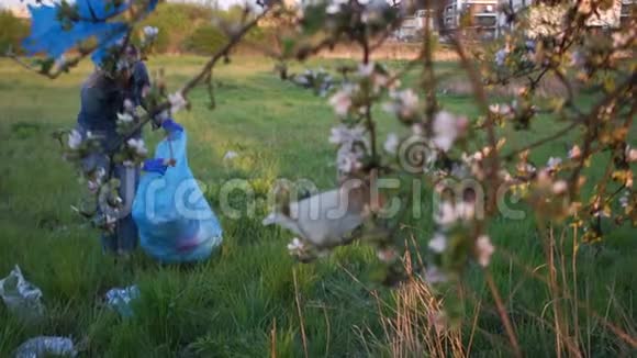 志愿者女收集垃圾在公园的树枝下美丽的苹果花国内问题视频的预览图