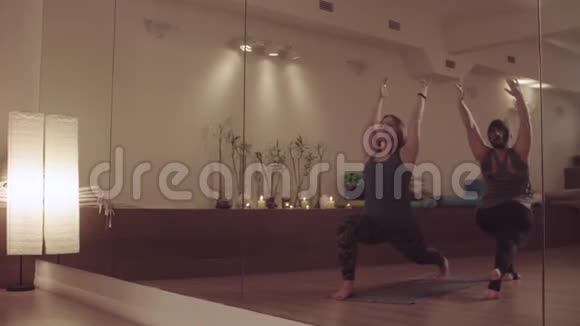 两个活跃的女性对称地做瑜伽练习视频的预览图