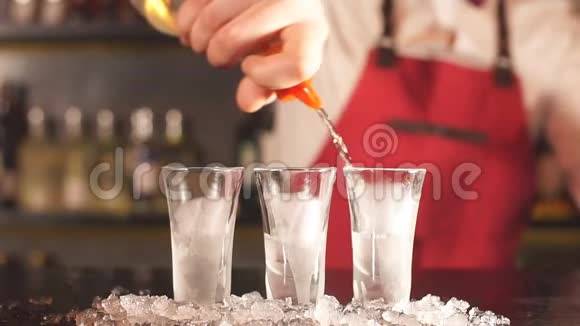 穿着优雅制服的专家酒吧服务员用磨砂短杯倒伏特加视频的预览图