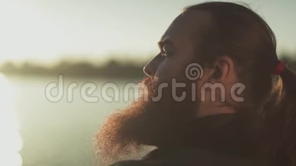一个留着长胡子的人在阳光下的肖像靠近视频的预览图