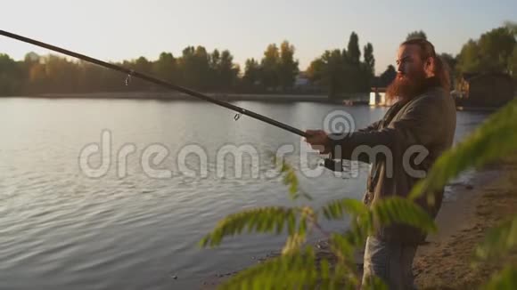 渔夫正拿着鱼竿钓鱼费舍尔提高和降低旋转视频的预览图