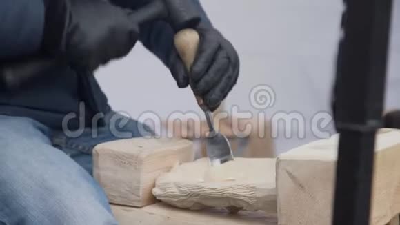 在木工的工作台上用凿子把手工雕刻的手收起来视频的预览图