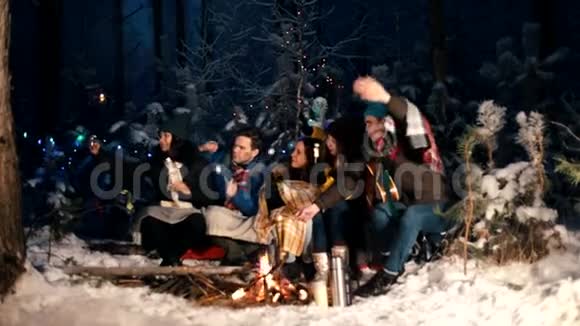 一群朋友坐在冬天的森林里吃着棉花糖自拍视频的预览图