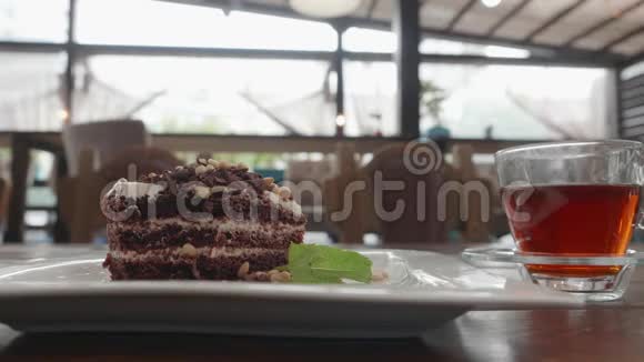 用勺子把巧克力饼切下来在咖啡馆喝茶亲密的男人喝着黑茶和巧克力蛋糕视频的预览图