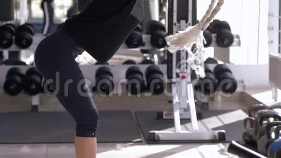 运动女性在健身俱乐部训练时在牵引模拟器上进行肌肉锻炼视频的预览图