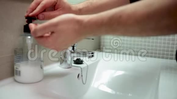 一个成年人在浴室里用肥皂和水洗手以避免病毒感染冠状病毒COVID19视频的预览图