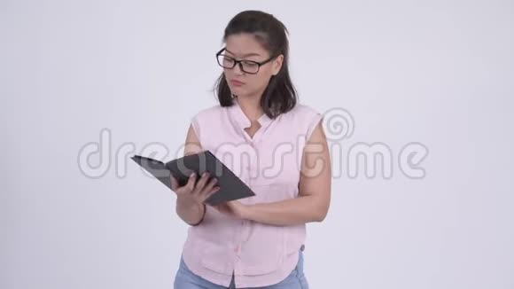 年轻漂亮的亚洲女商人看书心烦意乱视频的预览图