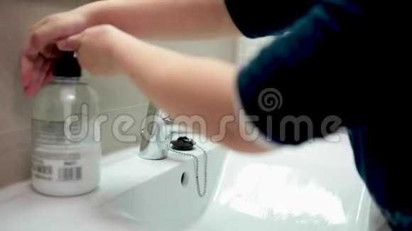 一个五岁的女孩在浴室里用肥皂和水洗手以避免病毒感染视频的预览图