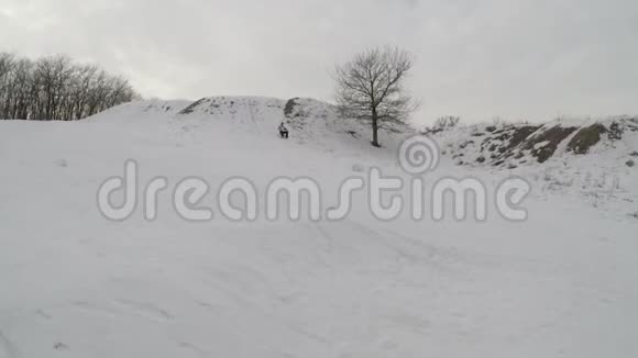 一个人从山上滑下雪橇冬天摔倒视频的预览图