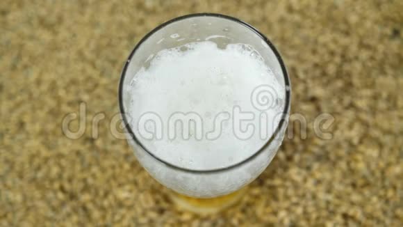 根据麦芽和啤酒花的经典配方在炊具中酿造的淡啤酒倒在一个玻璃杯中与之相对视频的预览图