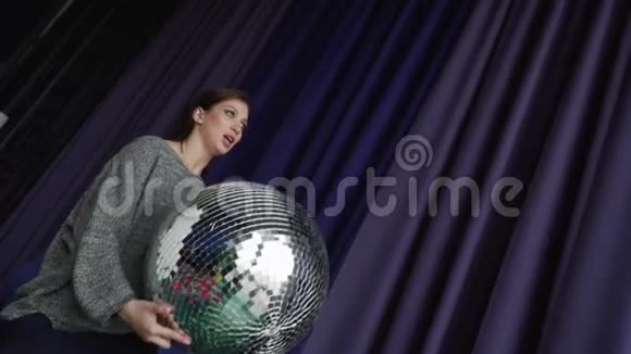 一个灰色的漂亮女孩手里拿着一个大迪斯科球视频的预览图