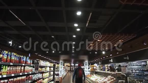 一个拿着篮子的人正走在超市的过道上视频的预览图