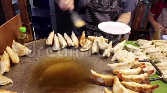 Gyoza从敞开的炉子里取出放在盘子里供顾客食用视频的预览图