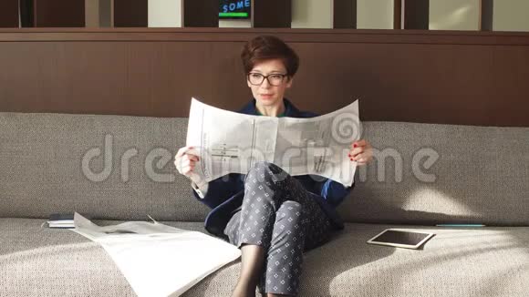 积极的商业女性上班后拿着报纸休息视频的预览图