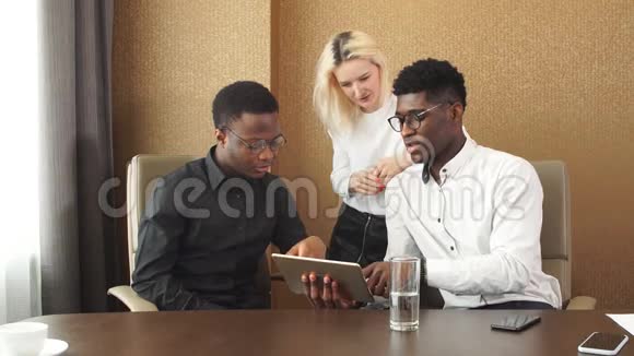 商务人士在办公桌前坐着时使用数字平板电脑视频的预览图