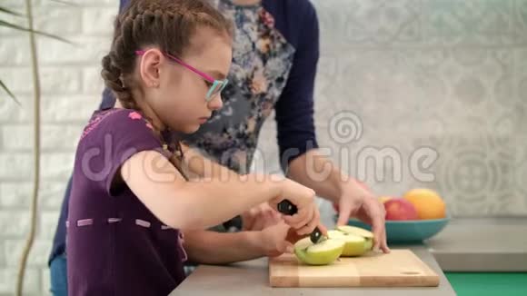 妈妈学女儿用刀妈妈和孩子一起切苹果片视频的预览图
