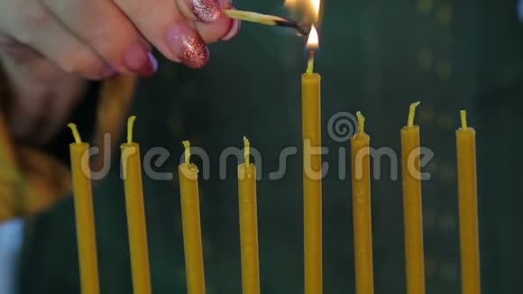 一只雌性手在光明节上用漂亮的烛台点燃蜡烛视频的预览图