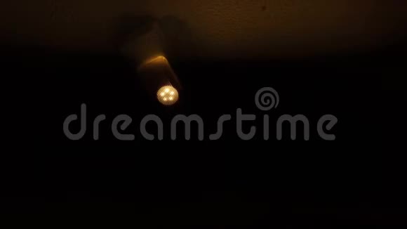 一盏令人毛骨悚然的灯在靠近砖墙的可怕走廊的天花板上闪烁着视频的预览图