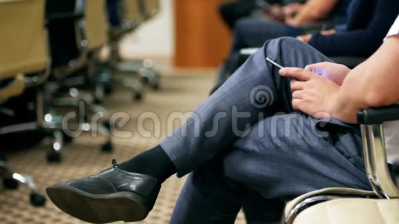 一个男人坐在会议上拿着电话视频的预览图
