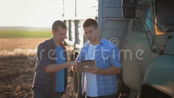 农户在麦地干活沟通看片两个农民在田间交谈用平板电脑视频的预览图