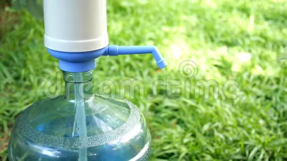 人的手把一个透明的水壶装满冷水从一个大瓶子或冷却器里用水泵反对视频的预览图