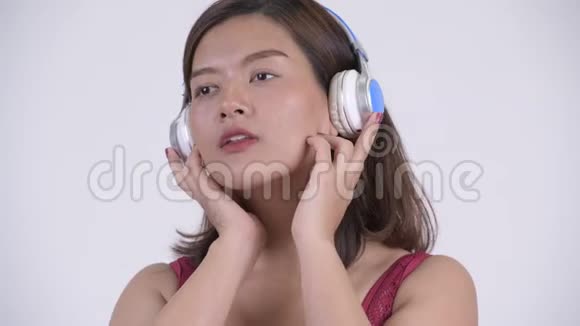 亚洲年轻旅游妇女听音乐的面孔视频的预览图
