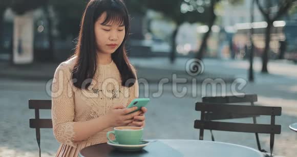 坐着咖啡和智能手机的女孩视频的预览图