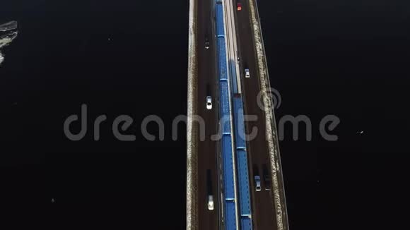 冬季城市冰冻河流上高速公路桥梁的空中观景车运动视频的预览图
