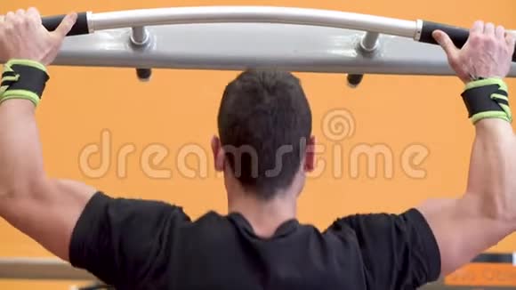 运动员肌肉健身男模在健身房的水平杆上拉起视频的预览图