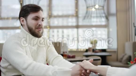 快乐的成年男人坐在咖啡馆里手里握着女人的手脸上还带着一种鼾声视频的预览图