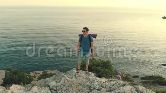 一个背着背包站在岩石上的人视频的预览图