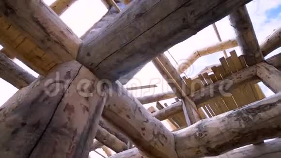 底部视野内未完成的木屋由圆木制成的蓝色多云的天空背景剪辑木工工程视频的预览图