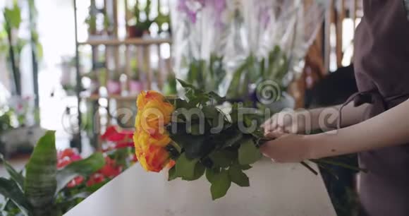 创意女孩花店在工作中用漂亮的构图布置一束玫瑰视频的预览图