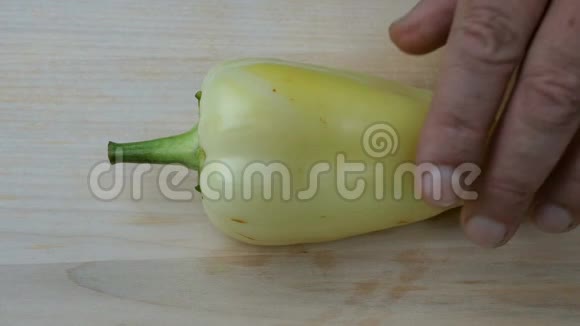 自制烹饪人类的双手用锋利的菜刀在一个木制的表面上切下一个甜的黄胡椒视频的预览图