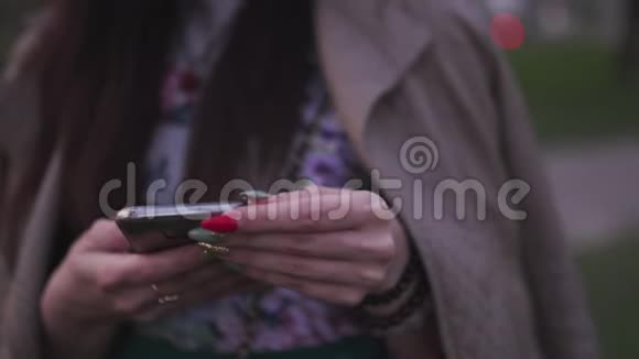 年轻女子用手机拍摄背景中的樱花生活方式视频的预览图
